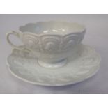A late 19thC ivory glazed porcelain shallow tea cup and saucer, decorated with moulded,