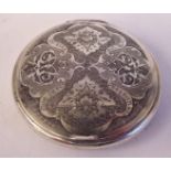 A Persian silver coloured metal disc design powder compact,