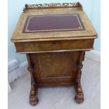 A late Victorian walnut Davenport with a low, fret carved gallery,