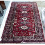 A Bokhara rug with seven diamond and hexagonal central guls, bordered by stylised designs,