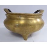 A late 19th/20thC Chinese cast bronze censer of squat, bulbous form with opposing, open lip handles,