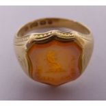 A late Victorian 15ct gold signet seal ring with an engraved armorial in a shield shaped cartouche