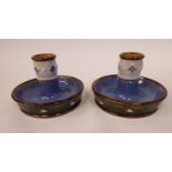 A pair of early 20thC Royal Doulton green, blue and brown glazed stoneware candleholders,