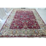 A Persian carpet, profusely decorated with flora, foliage and stylised designs,