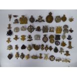 Approx fifty military cap badges and other insignia,