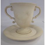 A late 18th/early 19thC Wedgwood biscuit glazed china twin handled pedestal cup and saucer bearing