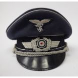 A German Luftwaffe peaked cap with silver braid,