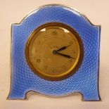 A 1930s white metal and engine turned powder blue enamel backed mantel timepiece;