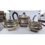 A matched silver three piece tea set comprising a teapot,