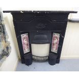 A late 19th/early 20thC black painted, cast iron fireplace surround, comprising a mantel shelf,