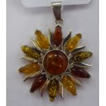 A silver coloured metal and multi-coloured amber set sun pendant 11