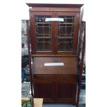 An Arts & Crafts oak bureau bookcase with a pair of glazed doors, over a fall flap,