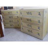 A pair of modern floral stencilled and yellow painted four drawer dressing chests,