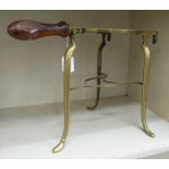 A mid Victorian lacquered brass trivet with a turned, mahogany handle,