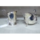 An Edwardian silver cream jug of helmet form;