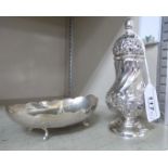 A foreign silver coloured metal shallow, oval sweet dish with a lobed border, on scrolled feet,