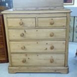 An early 20thC waxed pine dressing chest with two short/three long drawers,