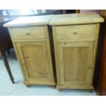 A pair of early 20thC waxed pine bedside cabinets, each with a single drawer, over a panelled door,