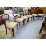 A set of six late Victorian and walnut framed, balloon back chairs with foliate carved ornament,