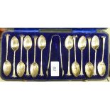 A set of twelve late Victorian silver teaspoons and matching sugar tongs with feathered bowls