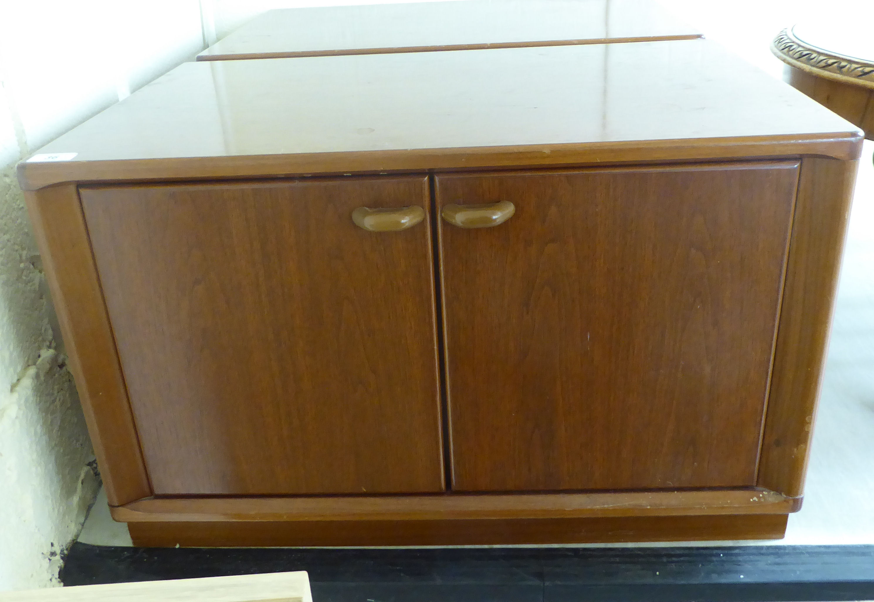 A pair of modern teak chests, each enclosed by a pair of doors,