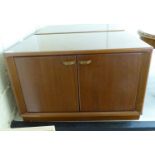 A pair of modern teak chests, each enclosed by a pair of doors,