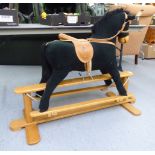 A Mamas & Papas nursery rocking horse, in black fabric with a mane, tail, saddle and reins,