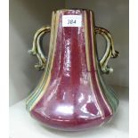 An Art Nouveau period studio porcelain, twin handled vase, decorated in tones of red and green 10.