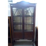 An Edwardian string inlaid mahogany display cabinet with twin glazed doors enclosing three shelves,