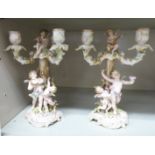 A pair of early 20thC Continental porcelain triple branch candelabra,