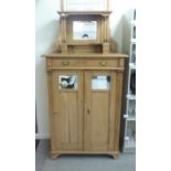 An early 20thC waxed pine kitchen unit, the top with a mirrored upstand,