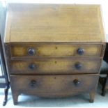 An early 20thC satinwood inlaid oak bureau, the fall flap over three graduated drawers,