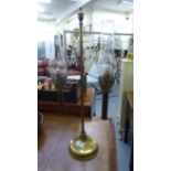 A late 19thC brass framed desk lamp with a twin branch, height adjustable column, on a splayed,
