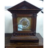 A late 19thC Continental oak cased mantel clock of architectural form;