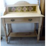 An early/mid 20thC bleached pine washstand with a pottery tiled upstand,