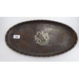 An early 20thC Hugh Wallis spot-hammered copper tray, having a rolled rim,