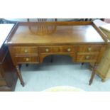 A late 19th/early 20thC mahogany five drawer kneehole desk, raised on ring turned,