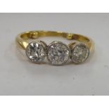 A yellow metal three stone diamond ring 11