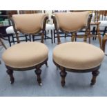 A pair of late Victorian ebonised and walnut framed salon chairs with fabric upholstered,