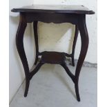 An Edwardian mahogany two tier, serpentine outlined occasional table,
