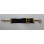 An 'antique' black satin and yellow metal mounted mourning watch pendant with a buckle,