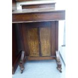 A late Victorian walnut Davenport with a hinged lid, over two marquetry panelled doors,