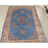 A Chinese woollen rug, decorated in traditional taste with roses,