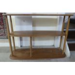 An Ercol pale coloured beech and elm freestanding, three tier bookcase/magazine rack,