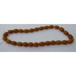A graduated amber coloured bead necklace 11