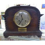 A 1920s oak cased mantel clock; the movement faced by a brushed steel Arabic dial,