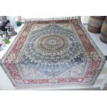 A silk rug, decorated with a graduated central serpentine outlined starburst motif,
