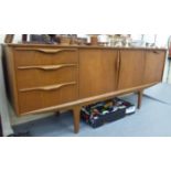 A 1970s teak sideboard, in the manner of McIntosh, comprising a central, two door cupboard,