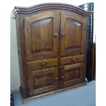 An early 20thC French panelled oak cupboard, having a round arched top, over a pair of doors,