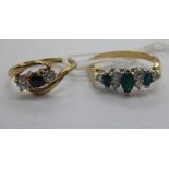 Two yellow metal rings, one set with emeralds and diamonds,